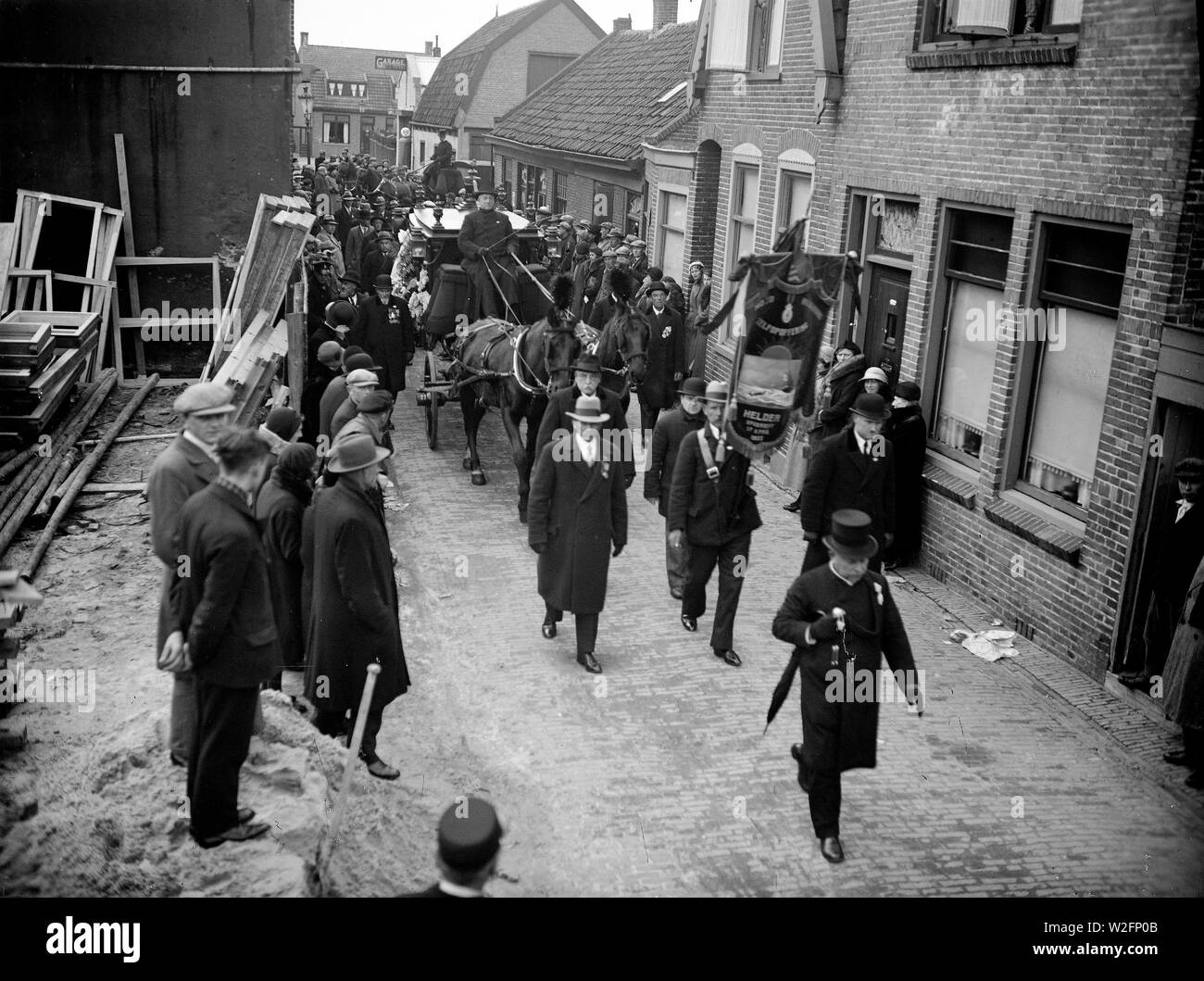 Funeral procession on foot through city streets in the Netherlands ca. 1928 Stock Photo