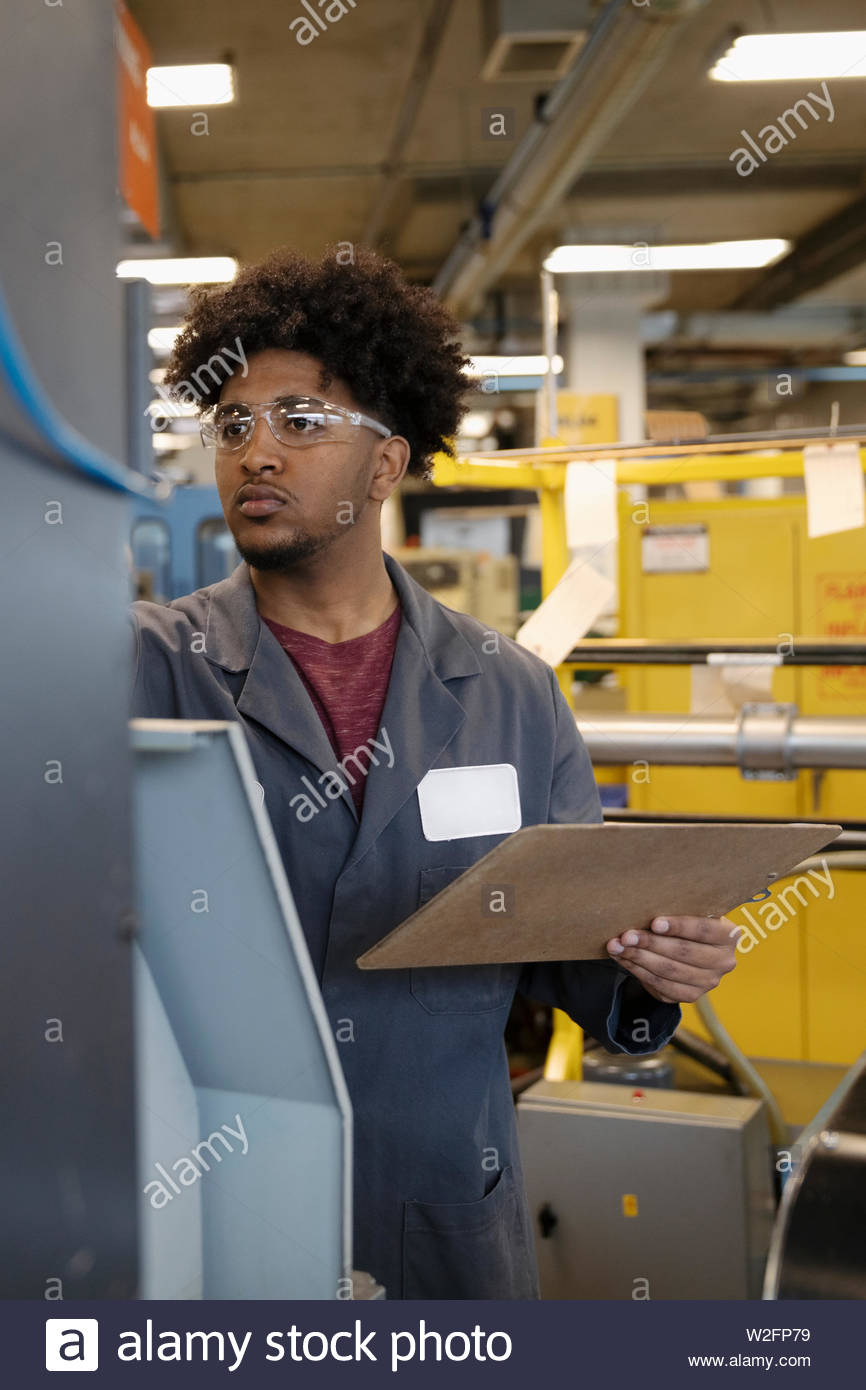Focused Machinist With Clipboard In Factory Stock Photo Alamy
