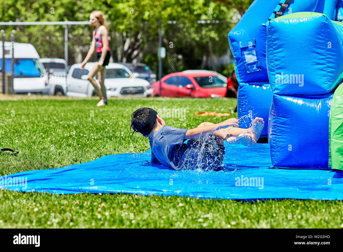 https://c8.alamy.com/comp/W2G3HD/prescott-arizona-usa-july-6-2019-young-boy-sliding-and-falling-upon-exiting-an-inflatable-water-slide-at-the-water-wars-on-the-mile-high-middle-sc-W2G3HD.jpg