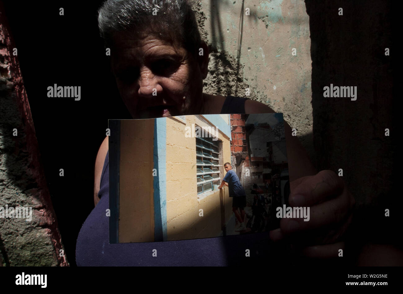 Gladys Santiago holds a photograph of her late son Carlos Santiago in her home's kitchen in Los Erasos shanty neighborhood in Caracas, July 22, 2008. Stock Photo