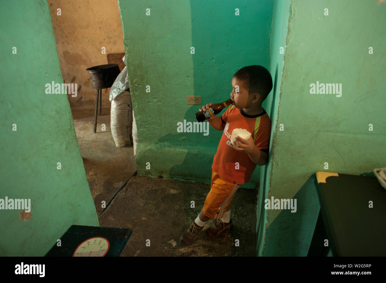 A boy eats lunch in her home's kitchen in Los Erasos shanty neighborhood in Caracas, Venezuela, July 22, 2008. Gladys lives with her sisters Emperatri Stock Photo