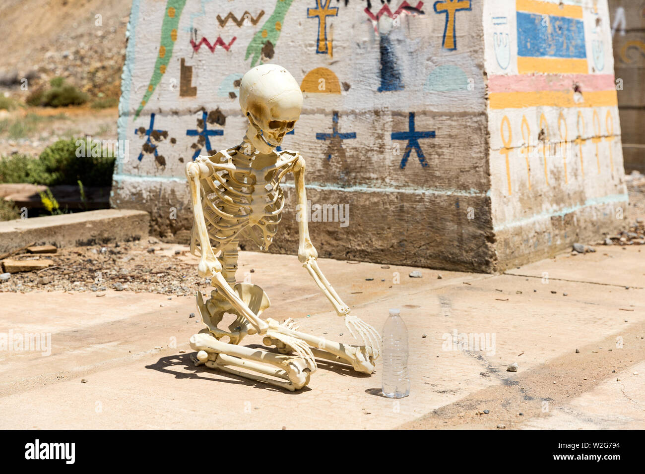 Skeleton worshipping a bottle of water at Ludwig mine Nevada ruins