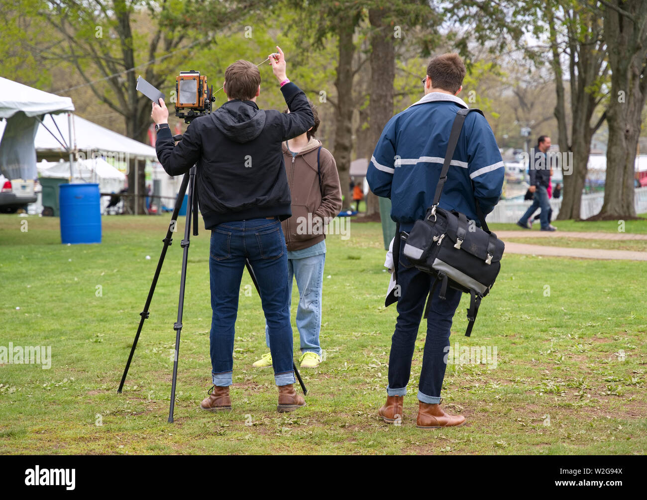 Meriden, CT USA. Apr 2019. Daffodil Festival. Young photographer demonstrating early American photography with this antique camera. Stock Photo