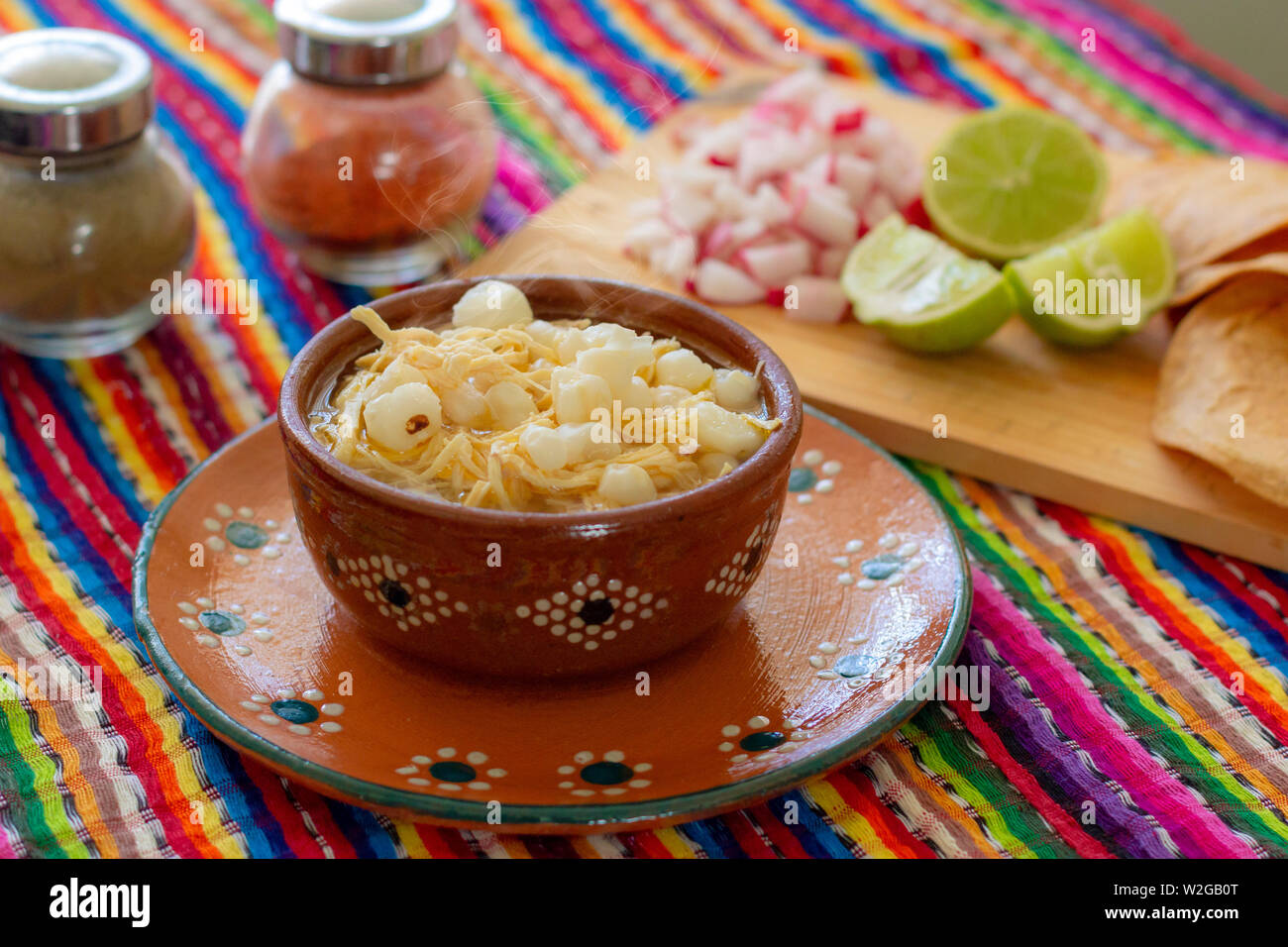Mexican cuisine, chicken pozole served with radishes, lemons and toast