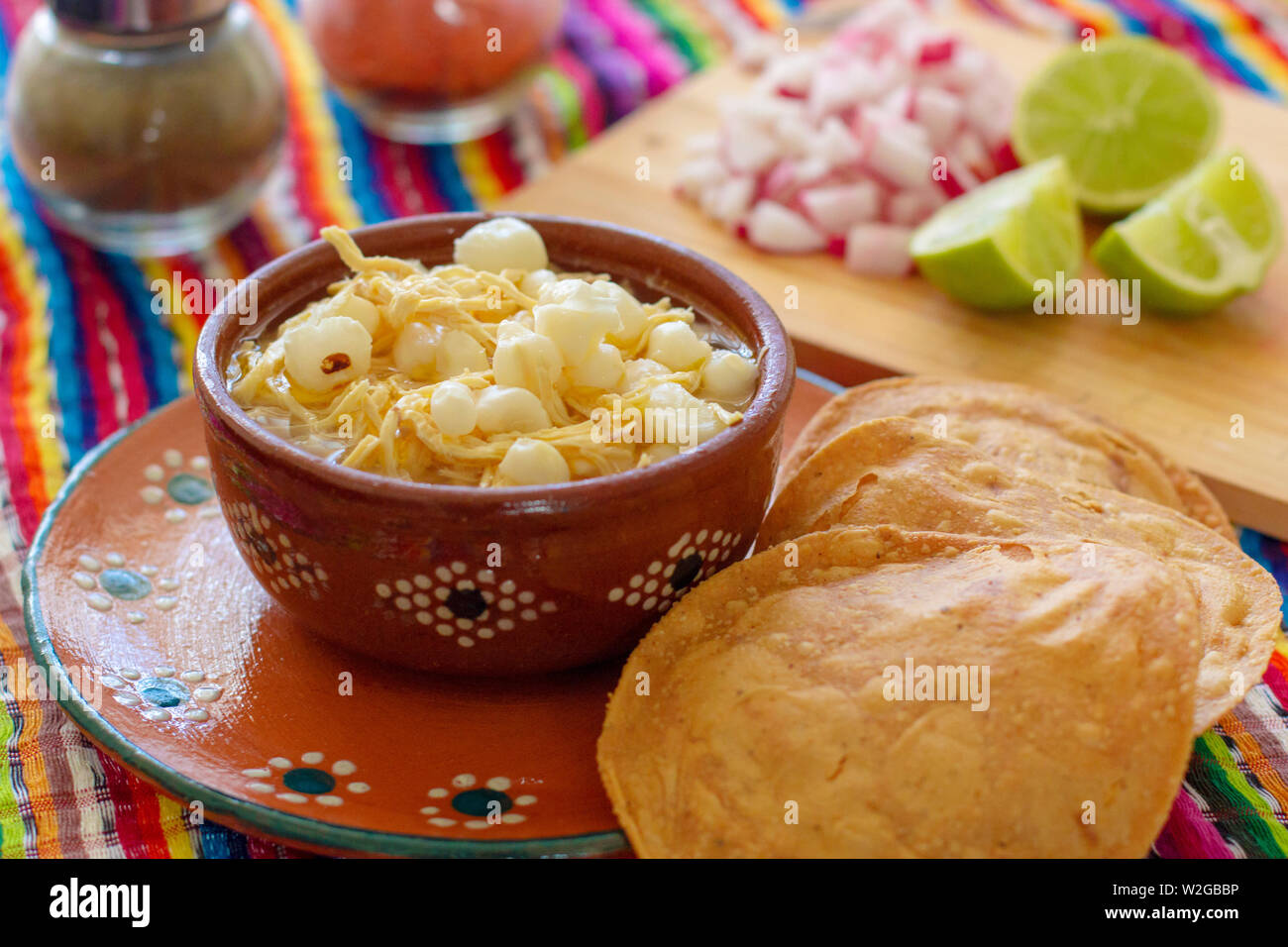 Mexican cuisine, chicken pozole served with radishes, lemons and toast