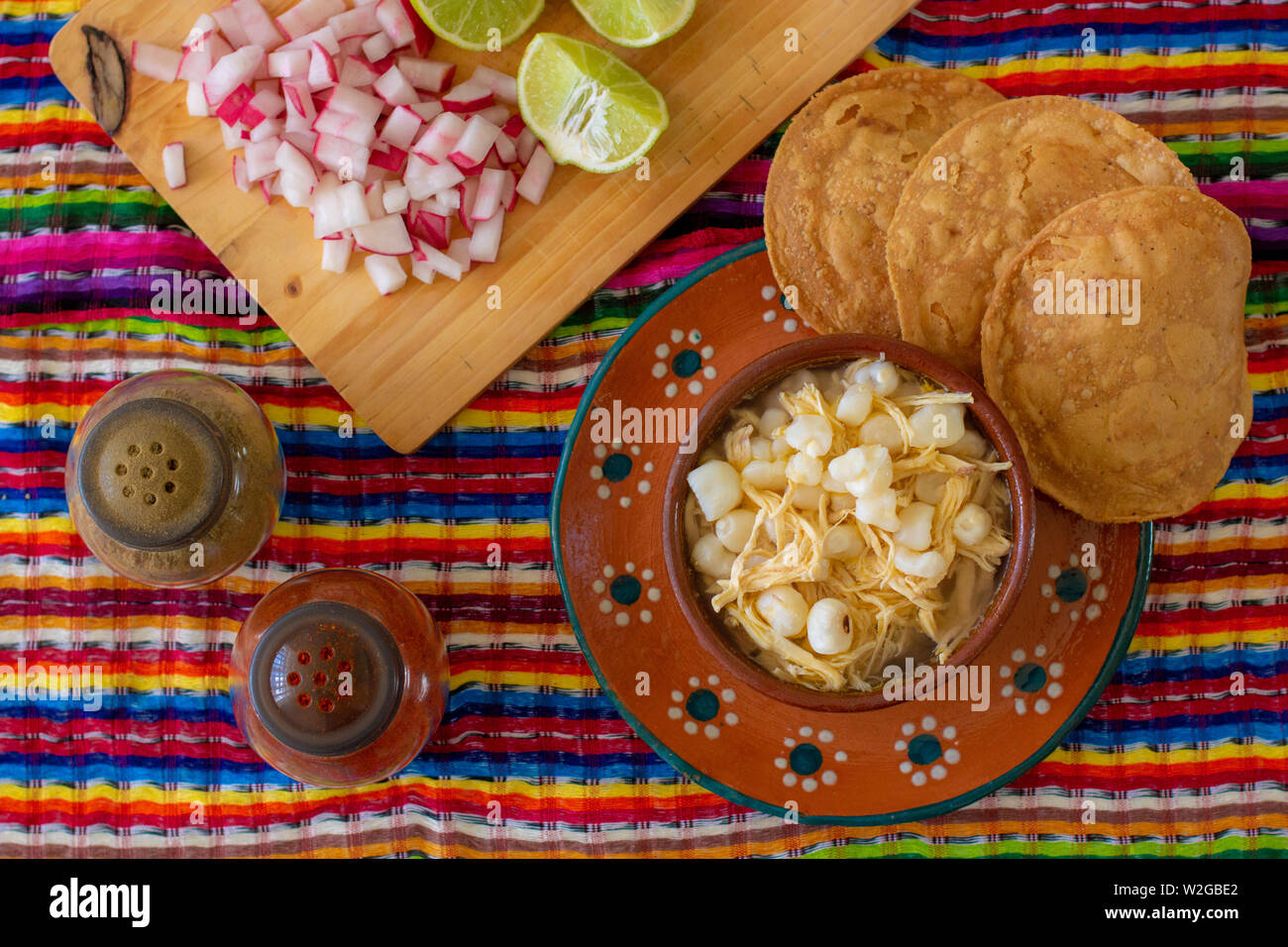 Mexican cuisine, chicken pozole served with radishes, lemons and toast