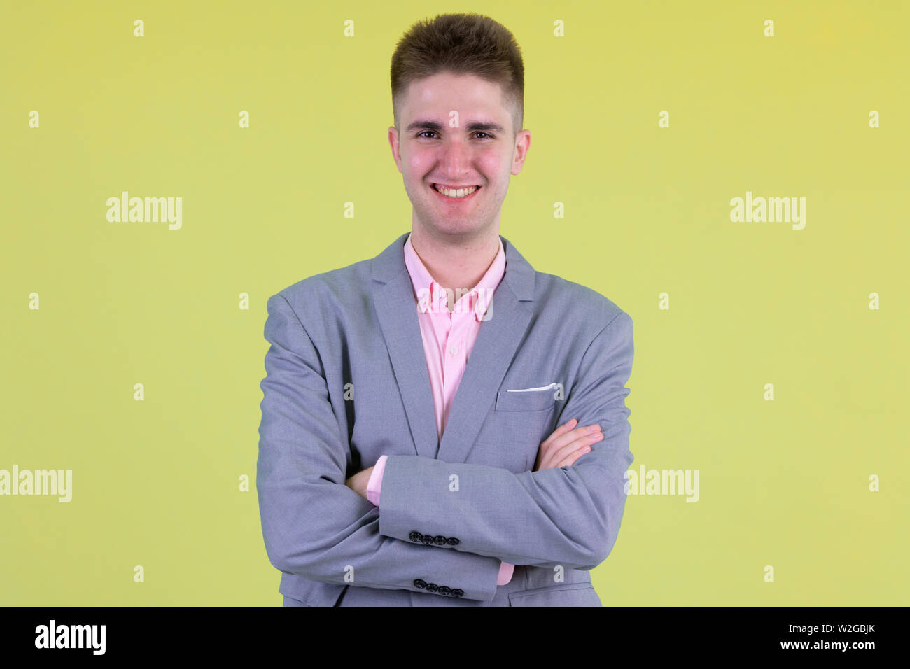Happy young handsome businessman smiling with arms crossed Stock Photo ...