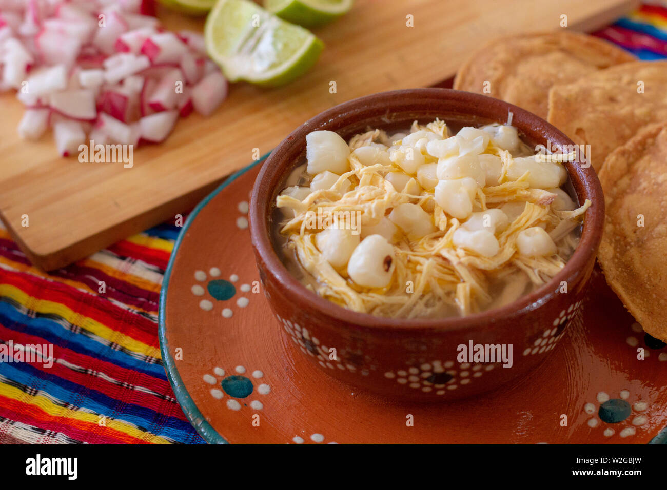 Mexican cuisine, chicken pozole served with radishes, lemons and toast