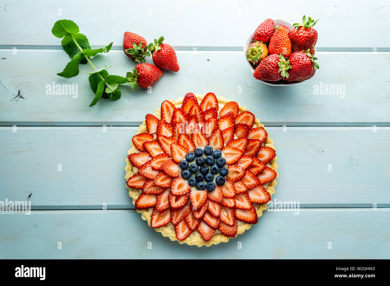 Cake with berries Pie with strawberries and blueberries on blue rustic table. Stock Photo