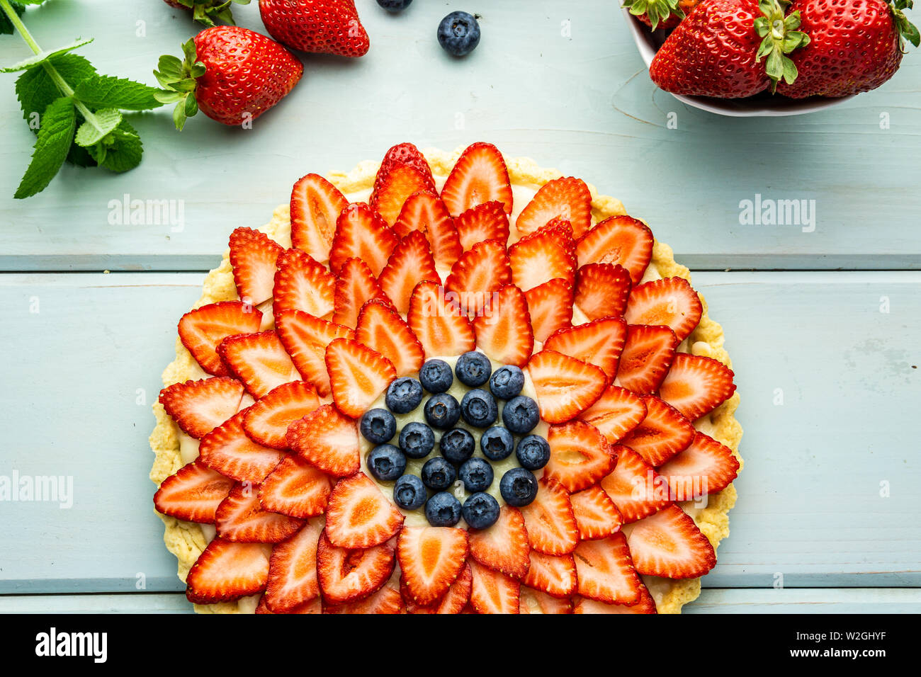 Cake with berries Pie with strawberries and blueberries on blue rustic table. Stock Photo