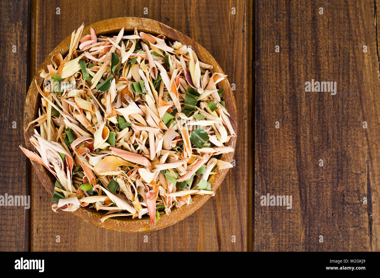 Dried lemongrass leaves in wooden bowl.  Stock Photo