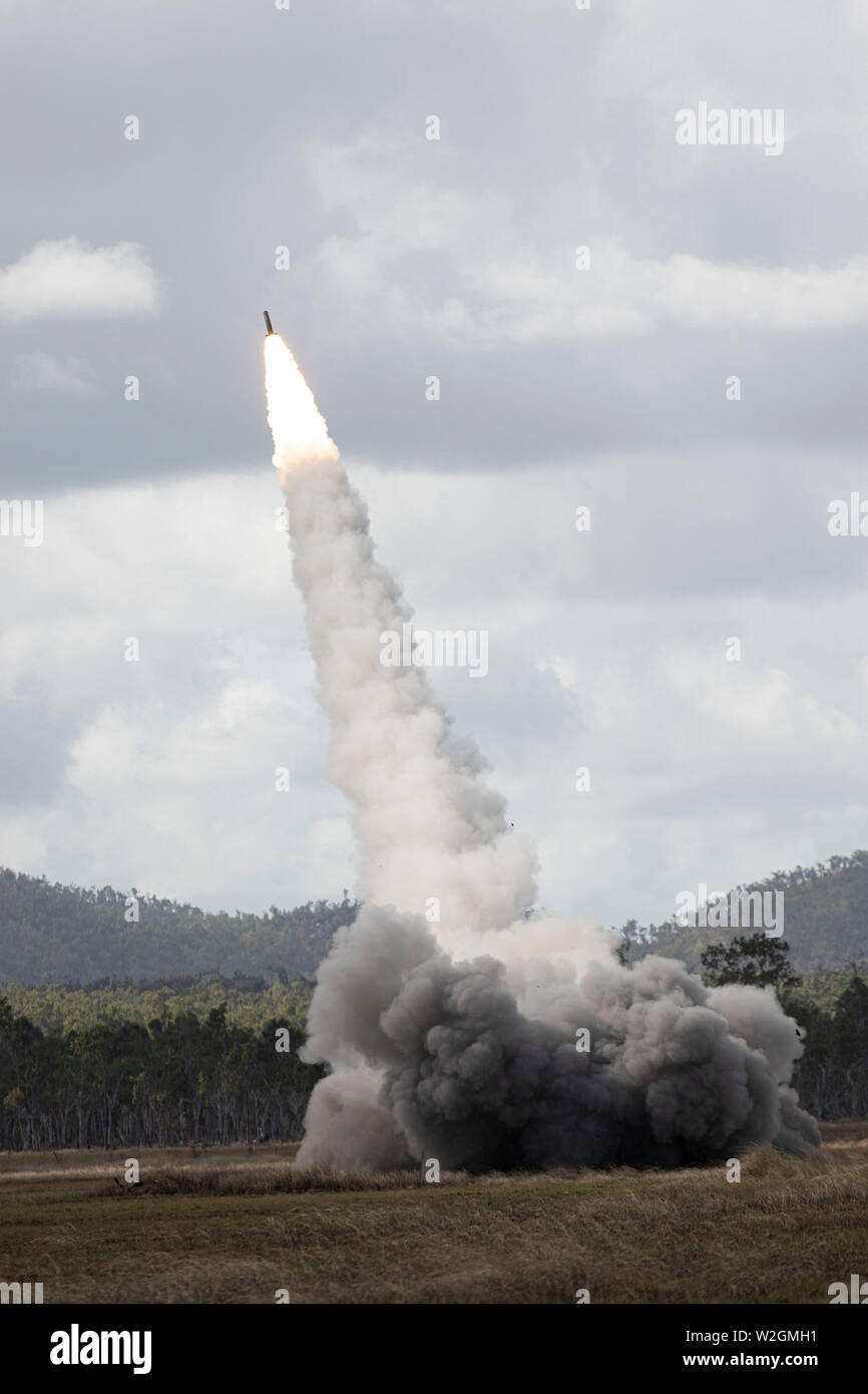 ROCKHAMPTON, Australia -- A High Mobility Artillery Rocket System shooting off one of 24 rockets that were shot simultaneously during a field training event of Exercise Talisman Saber 2019, at the Shoalwater Bay Training Area, July 7, 2019. During the exercise, they utilized the M142 HIMARS, AH-64 Apache attack helicopters, and High Mobility Transporters (HMT's), and showcased how the combined joint force communicates and maneuvers together as a team. Exercises like Talisman Saber provide effective and intense training to ensure U.S. and Australian forces are capable, interoperable and deploya Stock Photo