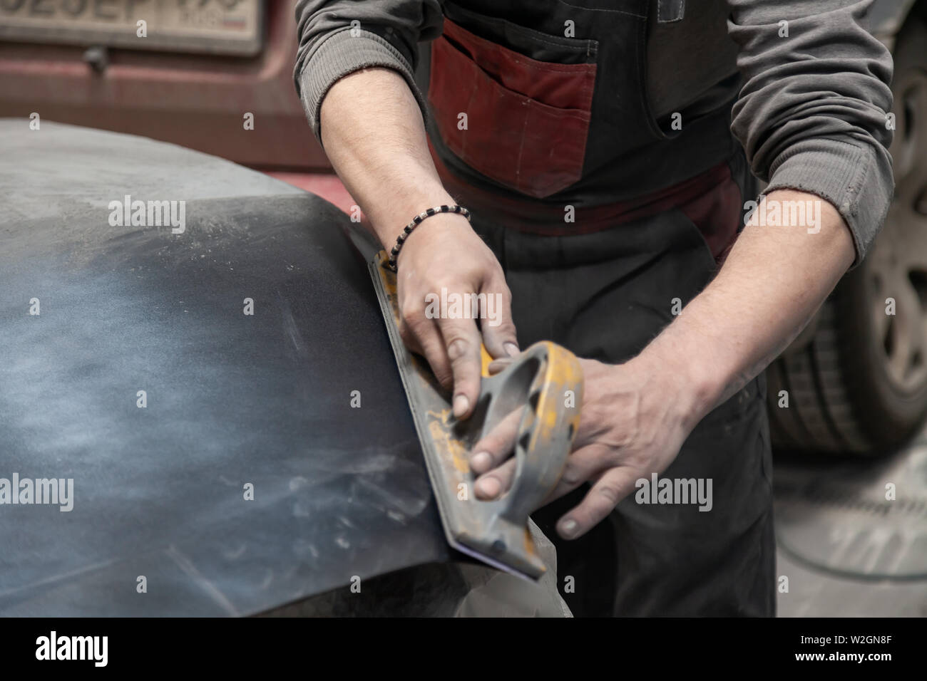 Preparation for painting a car element using emery sender by a service