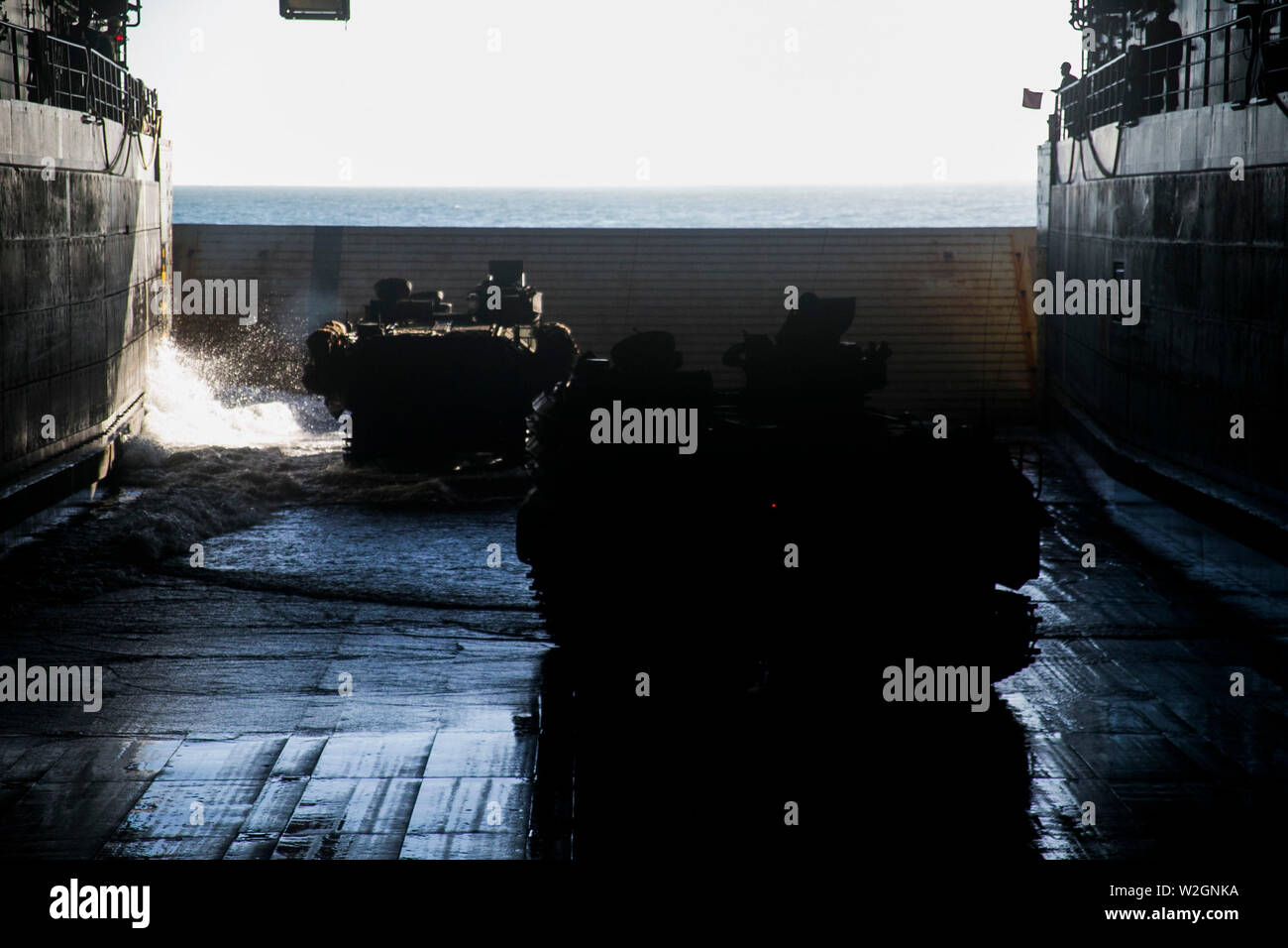 Assault Amphibious Vehicles with Battalion Landing Team, 2nd Battalion, 1st Marines, 31st Marine Expeditionary Unit, prepare for a simulated mechanized raid aboard the amphibious transport dock USS Green Bay (LPD 20), off the Coast of Townshend Island, Queensland Australia, July 1, 2019. Green Bay, part of the Wasp Amphibious Ready Group, with embarked 31st MEU, is operating in the Indo-Pacific region to enhance interoperability with partners and serve as a ready-response force for any type of contingency, while simultaneously providing a flexible and lethal crisis response force ready to perf Stock Photo