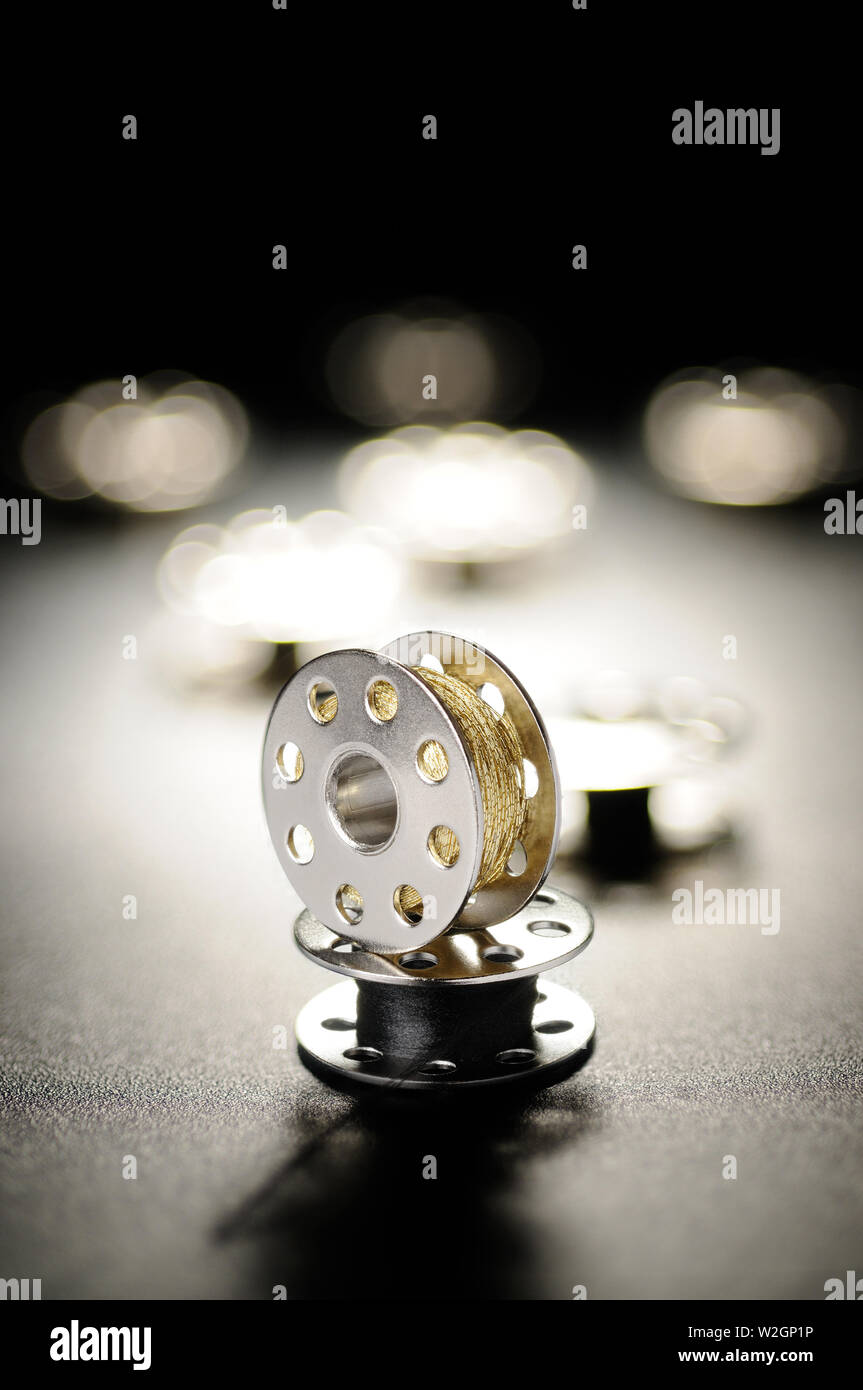 Metal spools of sewing machine on a black background Stock Photo Alamy