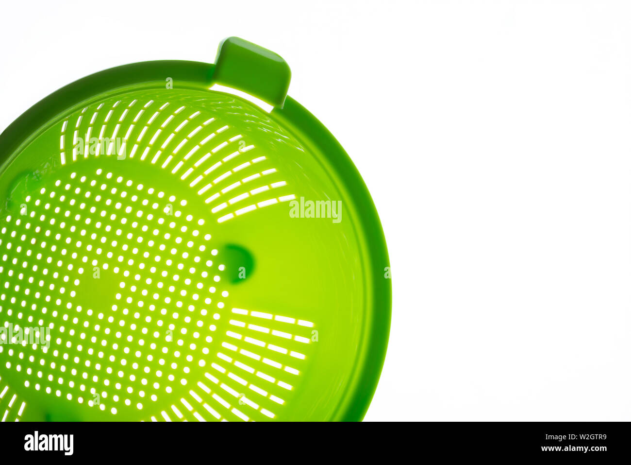 Close-up of a green plastic colander, a kitchen utensil to drain pasta, on  a white background. Photo with copy space Stock Photo - Alamy