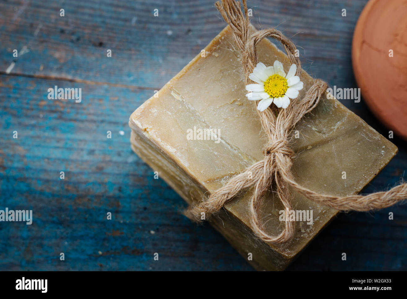 handmade olive soap and moroccan clay pumice on blue wooden background - home spa, hammam Stock Photo
