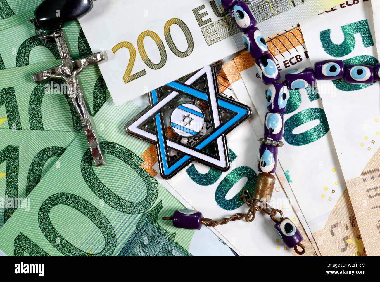 Banknotes of euro currency.  Christianity, Islamic and Judaism finance and economy concept with Jewish Star, Prayer Beads and Crucifix. Interreligious Stock Photo