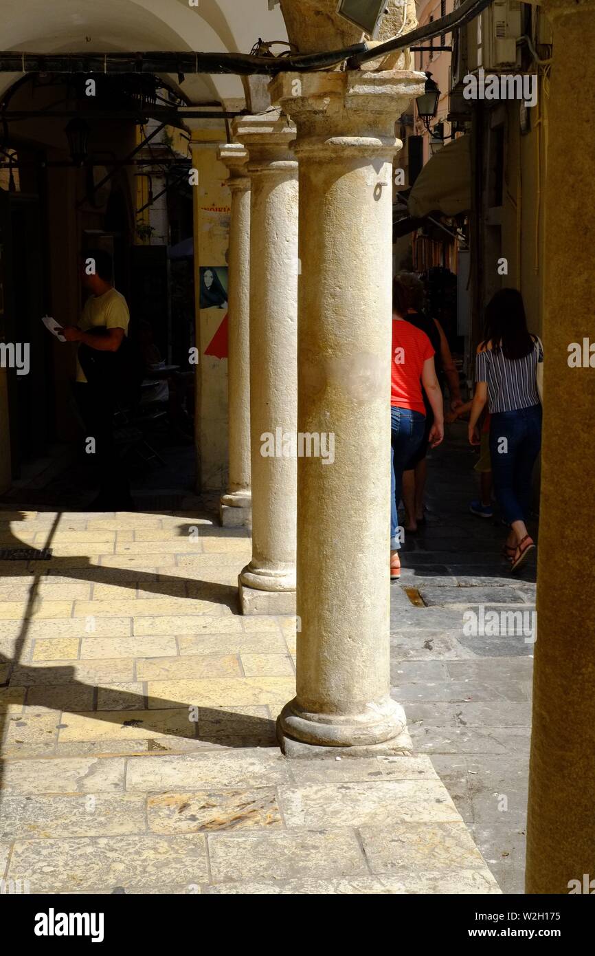 Corfu town street with stone pillars in town centre. lots of sun and shade in the scene very few people Stock Photo