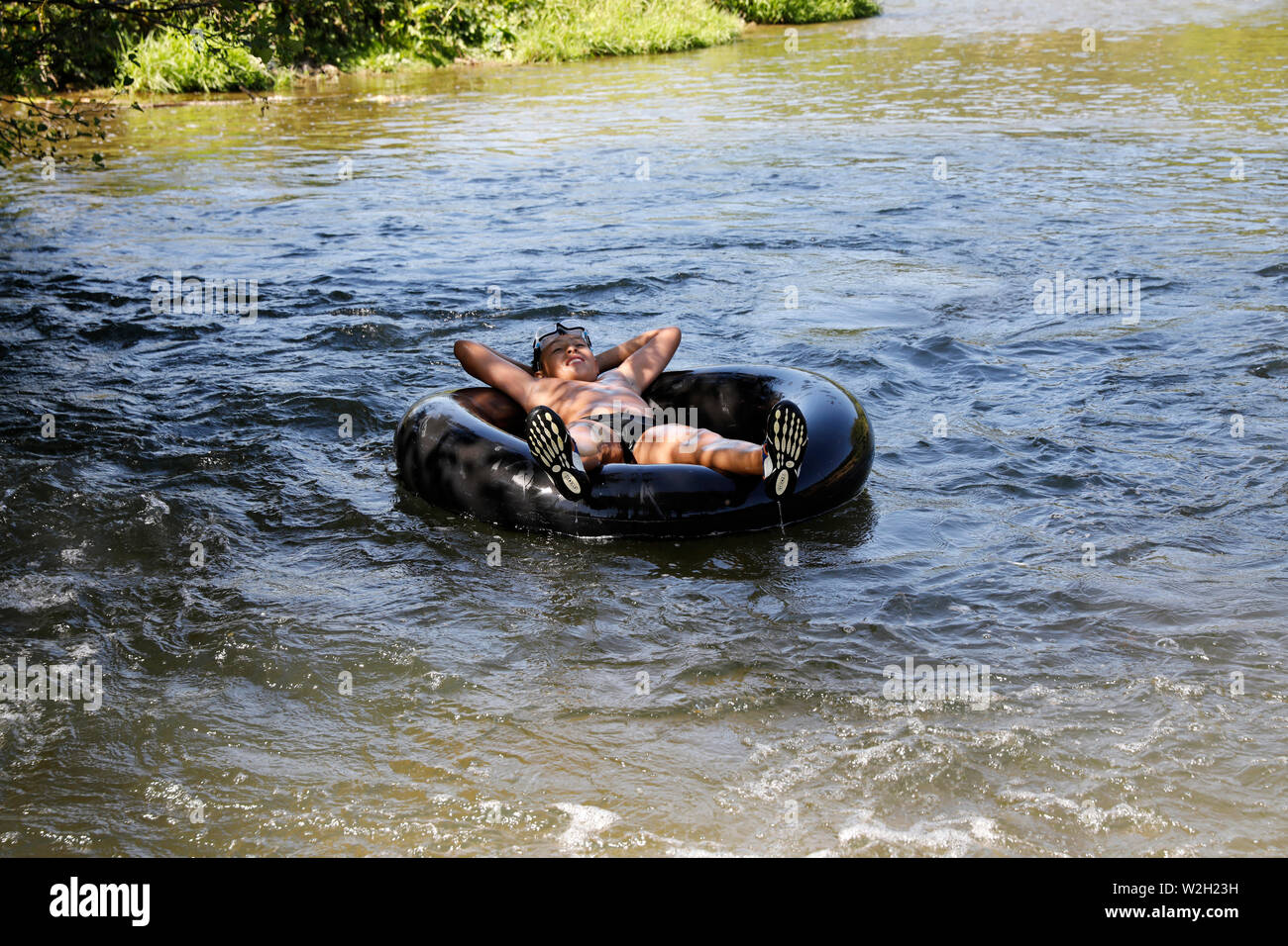 12-year-old boy floating on a rubber ring in Bosc-Renoult, France. Stock Photo