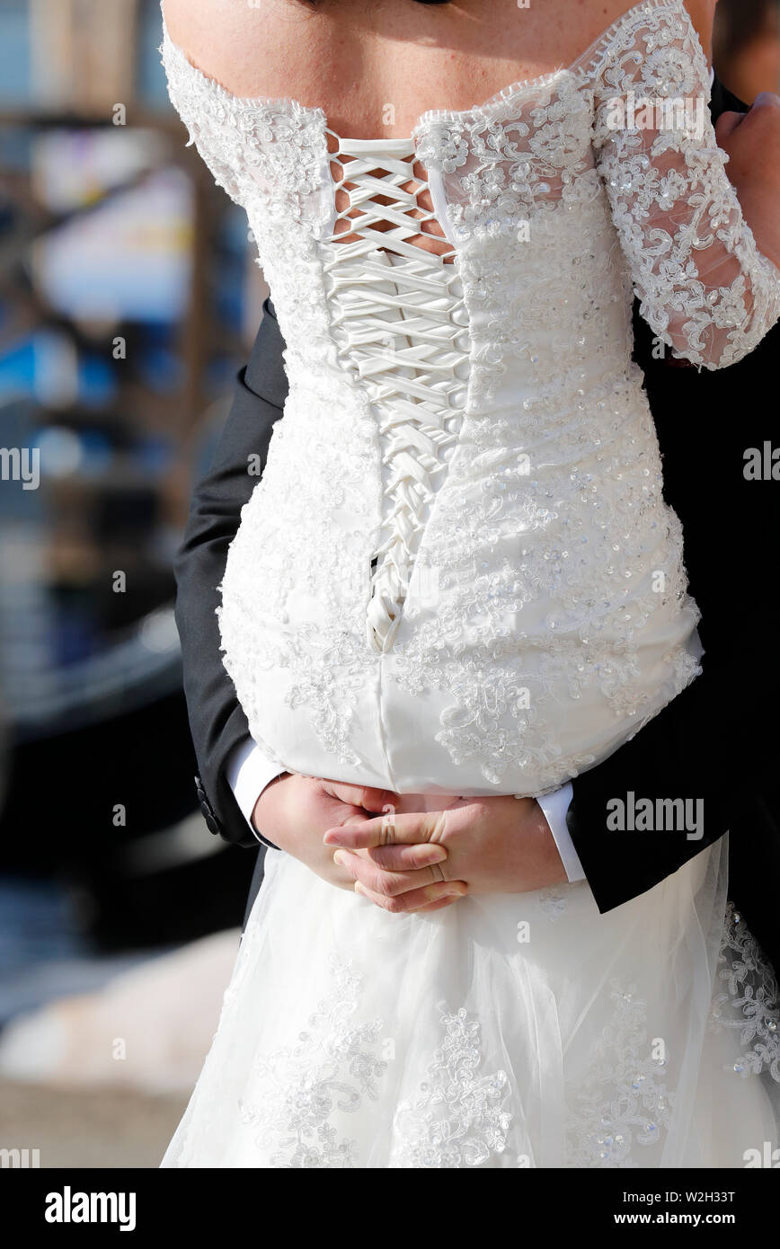 Rear view of bride and groom with arms around each other.  Venice. Italy. Stock Photo