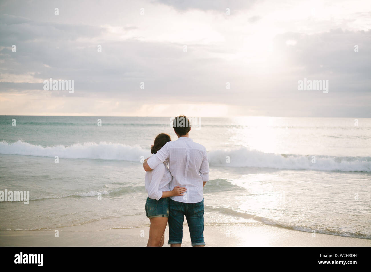 A man hugs a woman. They stand and look at the sea. Solitude together ...
