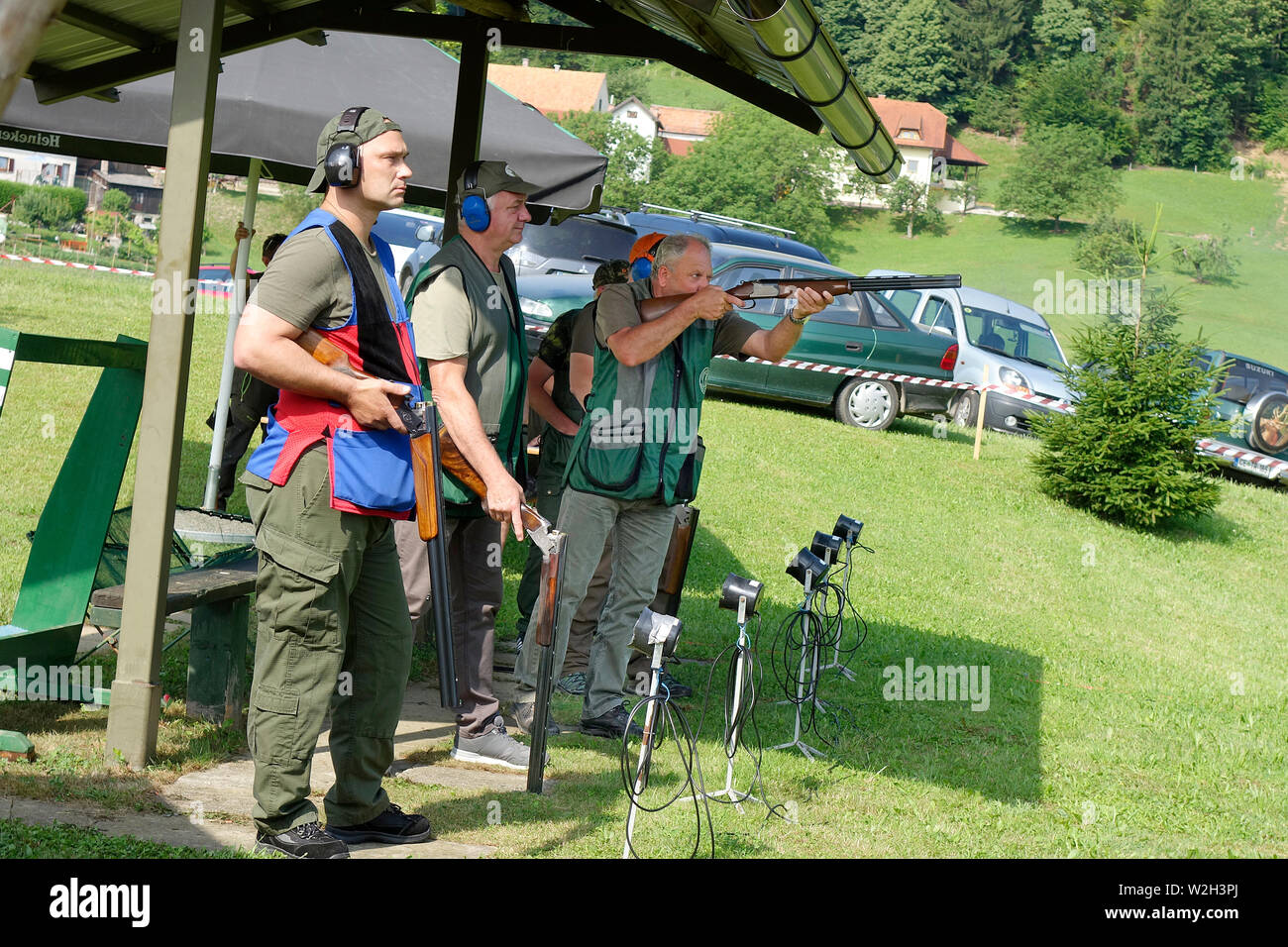 Trapshooting. Competitors shooting shotguns at clay targets Stock Photo