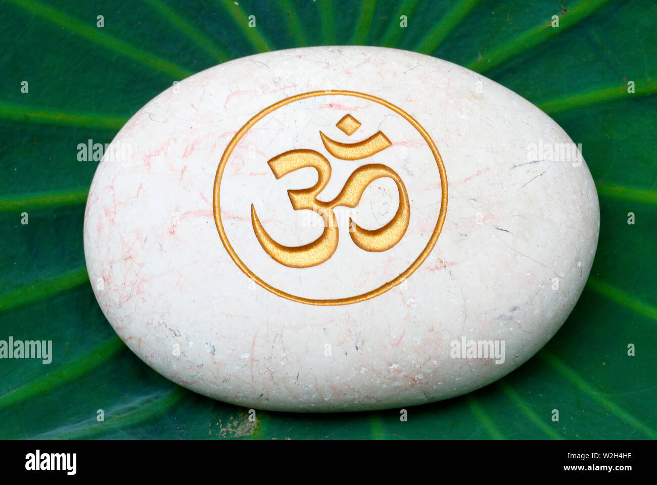 The Om Or Aum Symbol Of Hinduism And Buddhism Painted On A White Stone Stock Photo Alamy