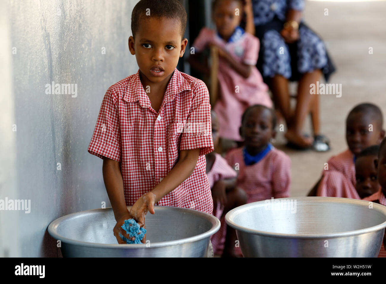 African primary school. A school boy washing his hands. Lome. Togo. Stock Photo