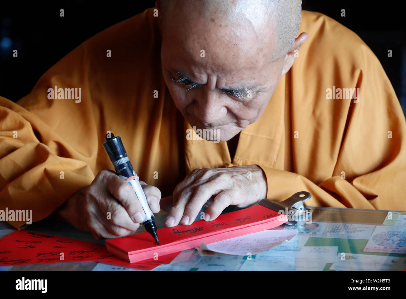 Old monk writing prayers for the deads.  Pho Da temple.  Vung Tau. Vietnam. Stock Photo
