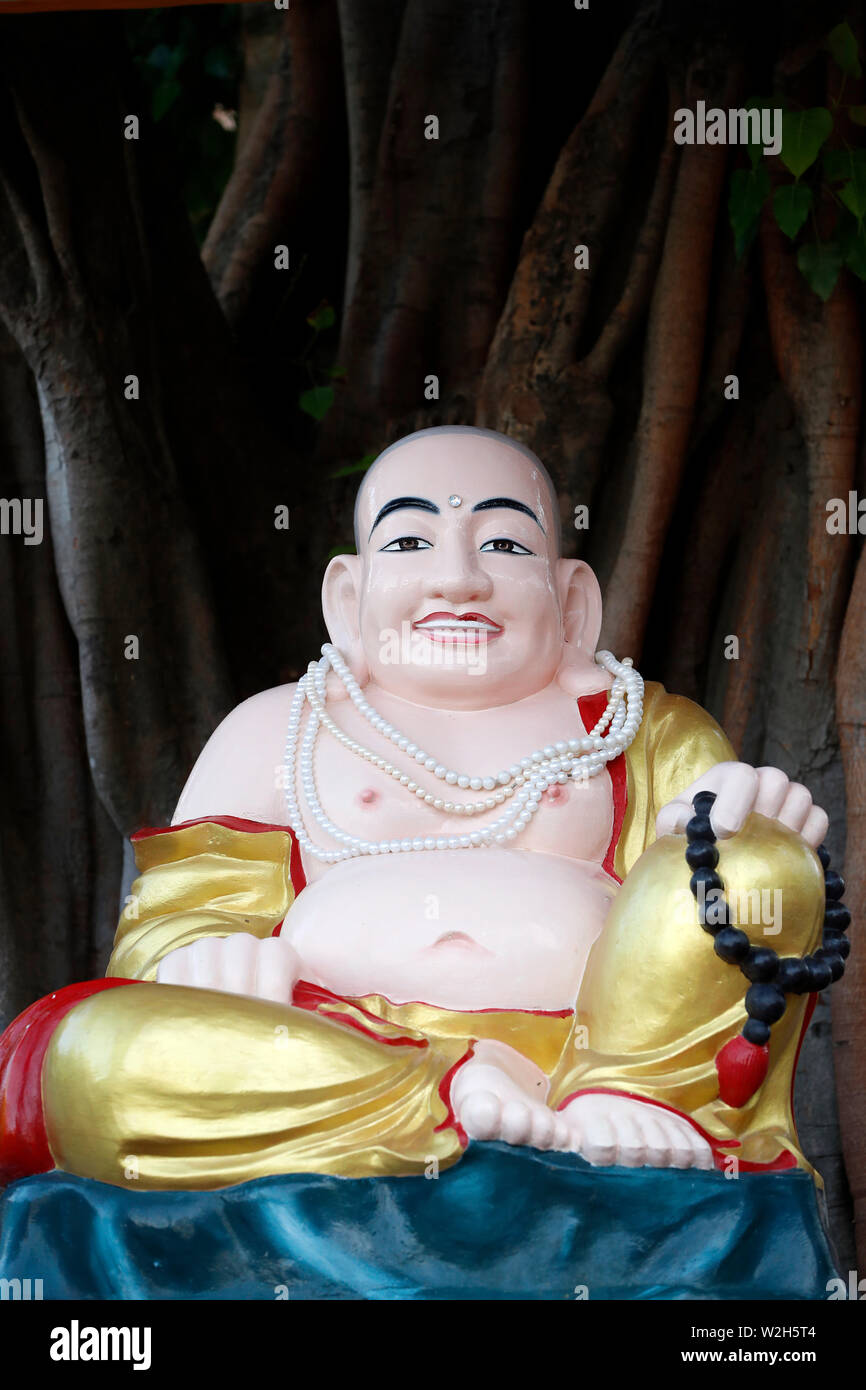 The celestial Buddha named Pu-Tai is traditionally depicted as an obese, bald man wearing a robe and carrying prayer beads. His large stomach and joll Stock Photo