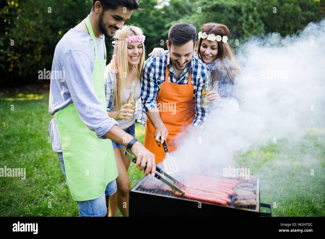 Group of happy friends having barbecue party in forest Stock Photo - Alamy