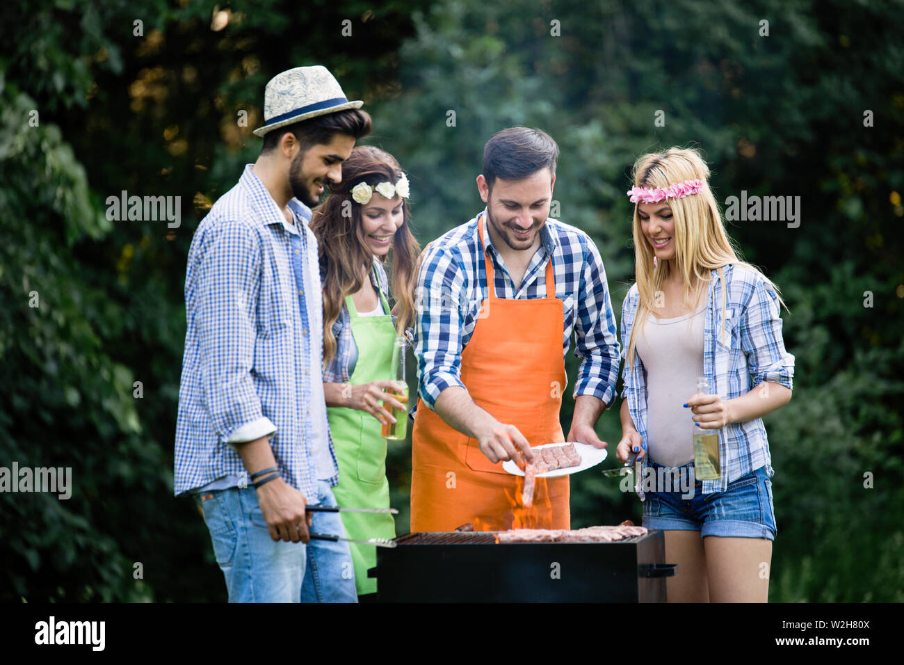 Group of happy friends having barbecue party in forest Stock Photo - Alamy