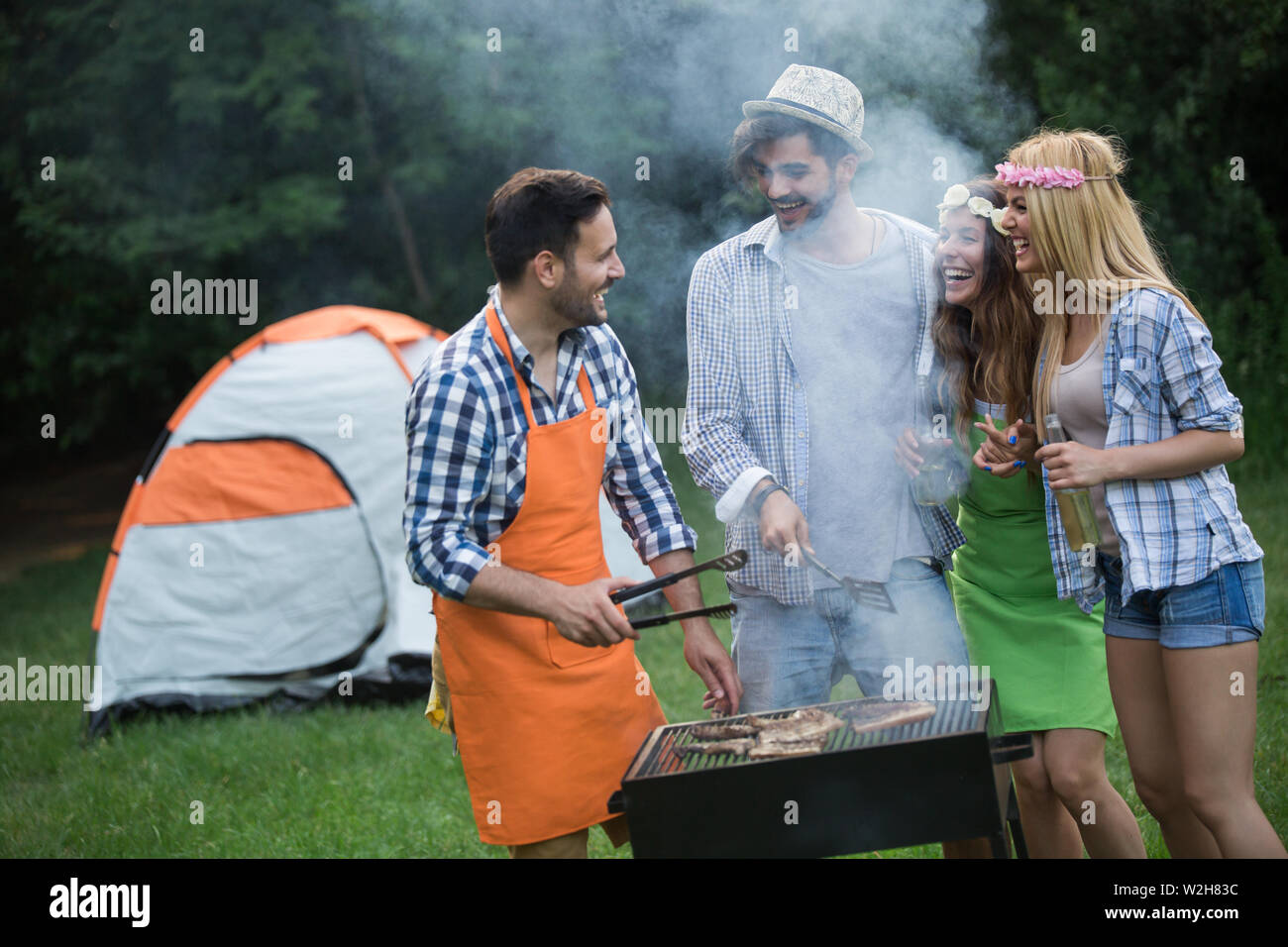 Group of happy friends having barbecue party in forest Stock Photo - Alamy