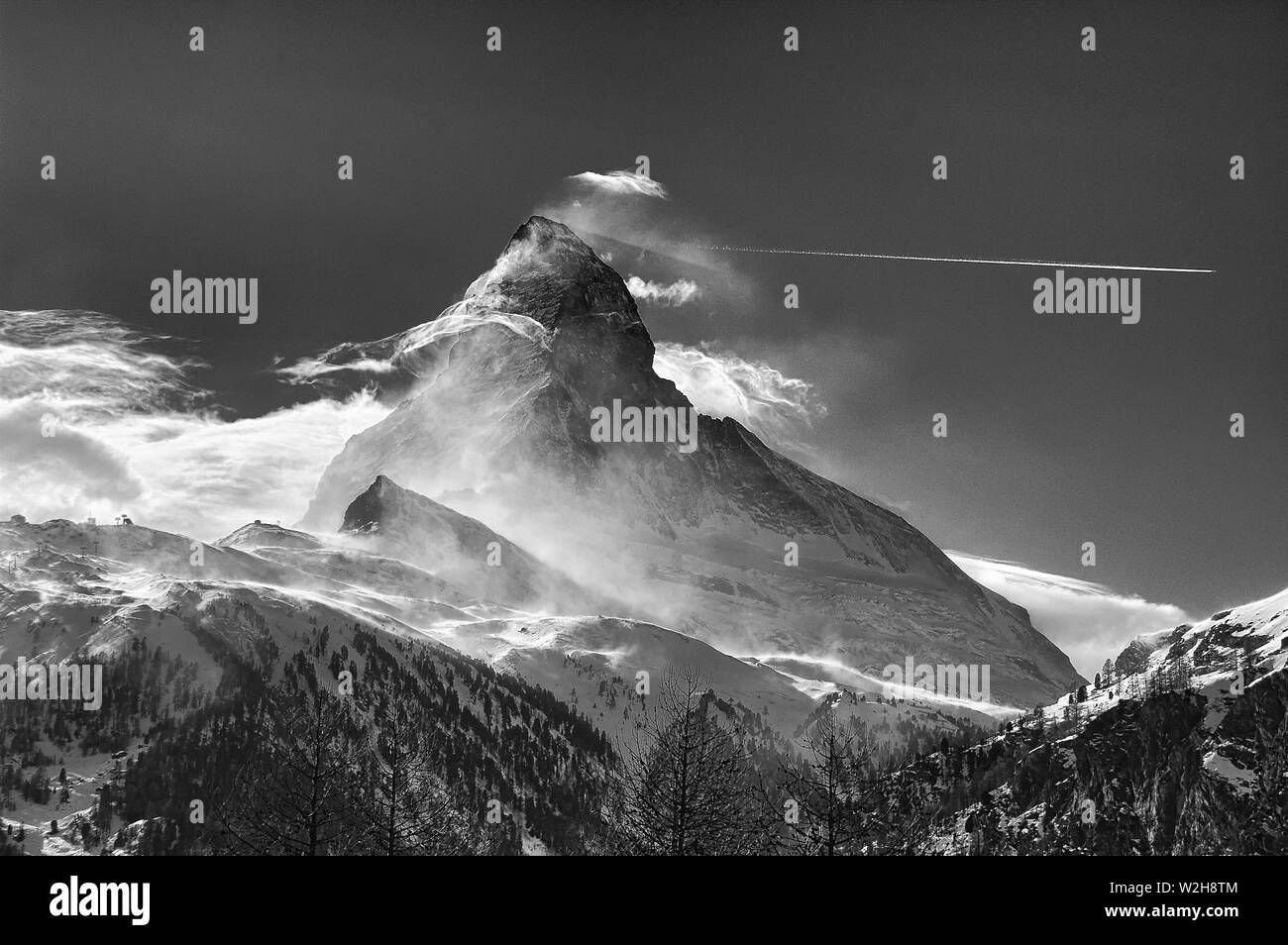 B&W photo of an airplane seems to escape from the Matterhorn Stock Photo