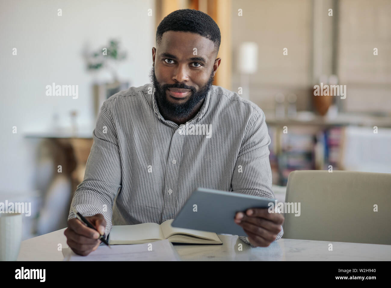 Smiling African American man using a digital tablet at home Stock Photo