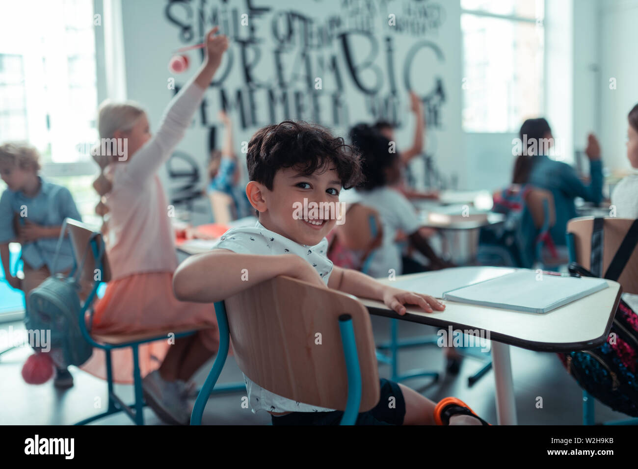 At Back Little boy smiling sitting in the back of the classroom Stock Photo - Alamy