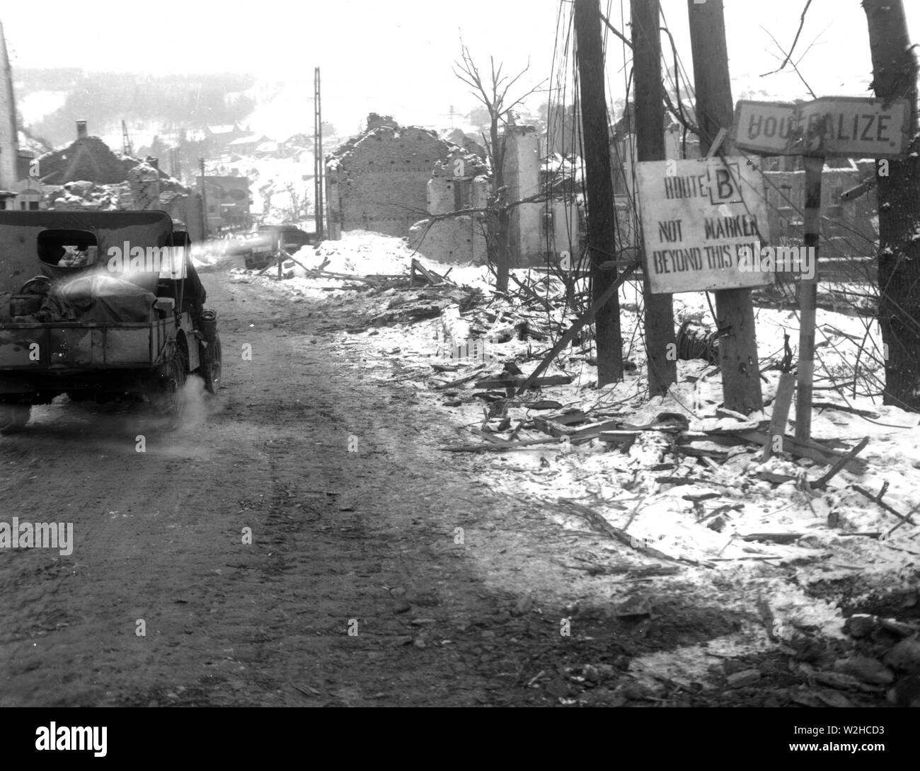 Original caption: An American jeep enters the shell-torn town of Houffalize, Belgium, by the main road. The town was retaken from the Germans by the 2nd Armored Division. 1/18/45 Stock Photo