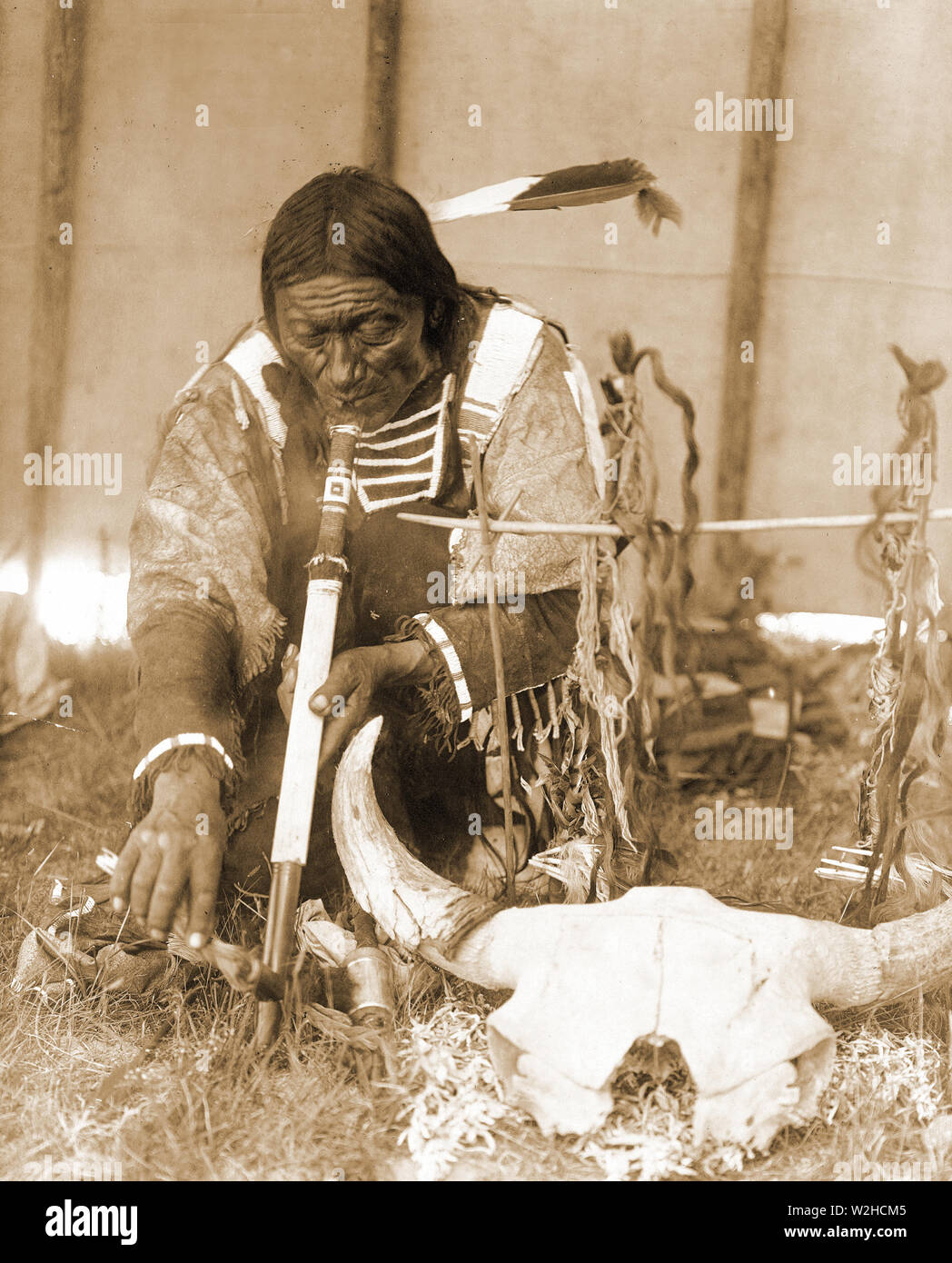 Edward S. Curtis Native American Indians - Dakota man with calumet kneeling by altar inside tipi ca. 1907 Stock Photo