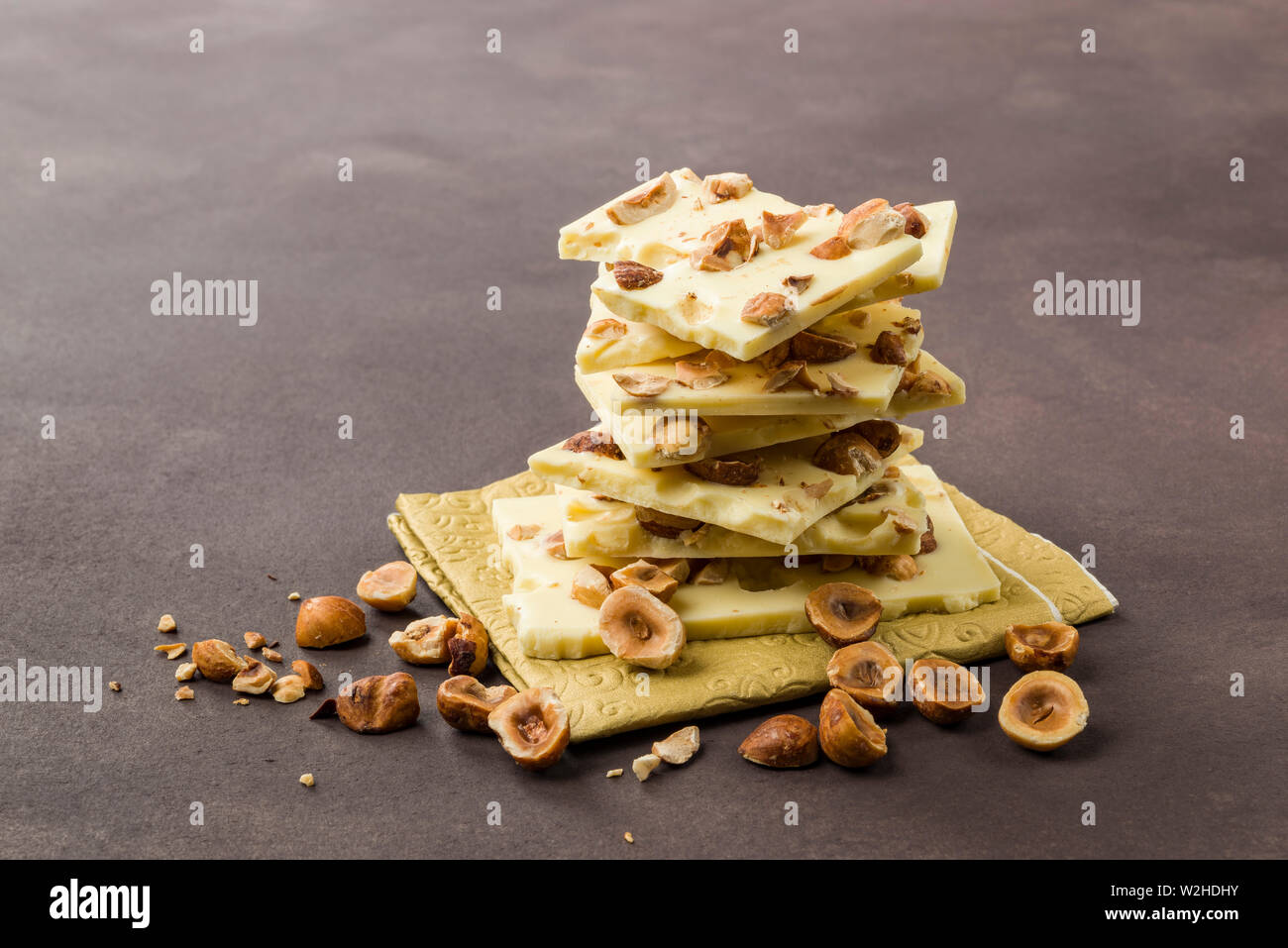 hazelnut white chocolate pieces on brown background Stock Photo - Alamy