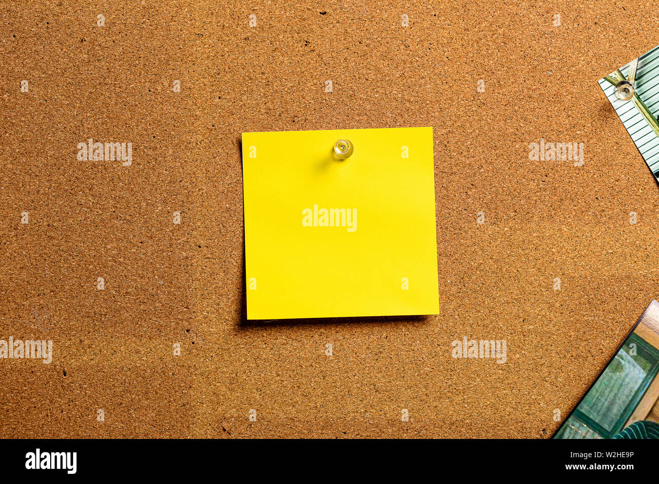 Corkboard/Bulletin Board with a single yellow Sticky Note centered on the board.  The note is perfect for accentuating a point while using the open co Stock Photo