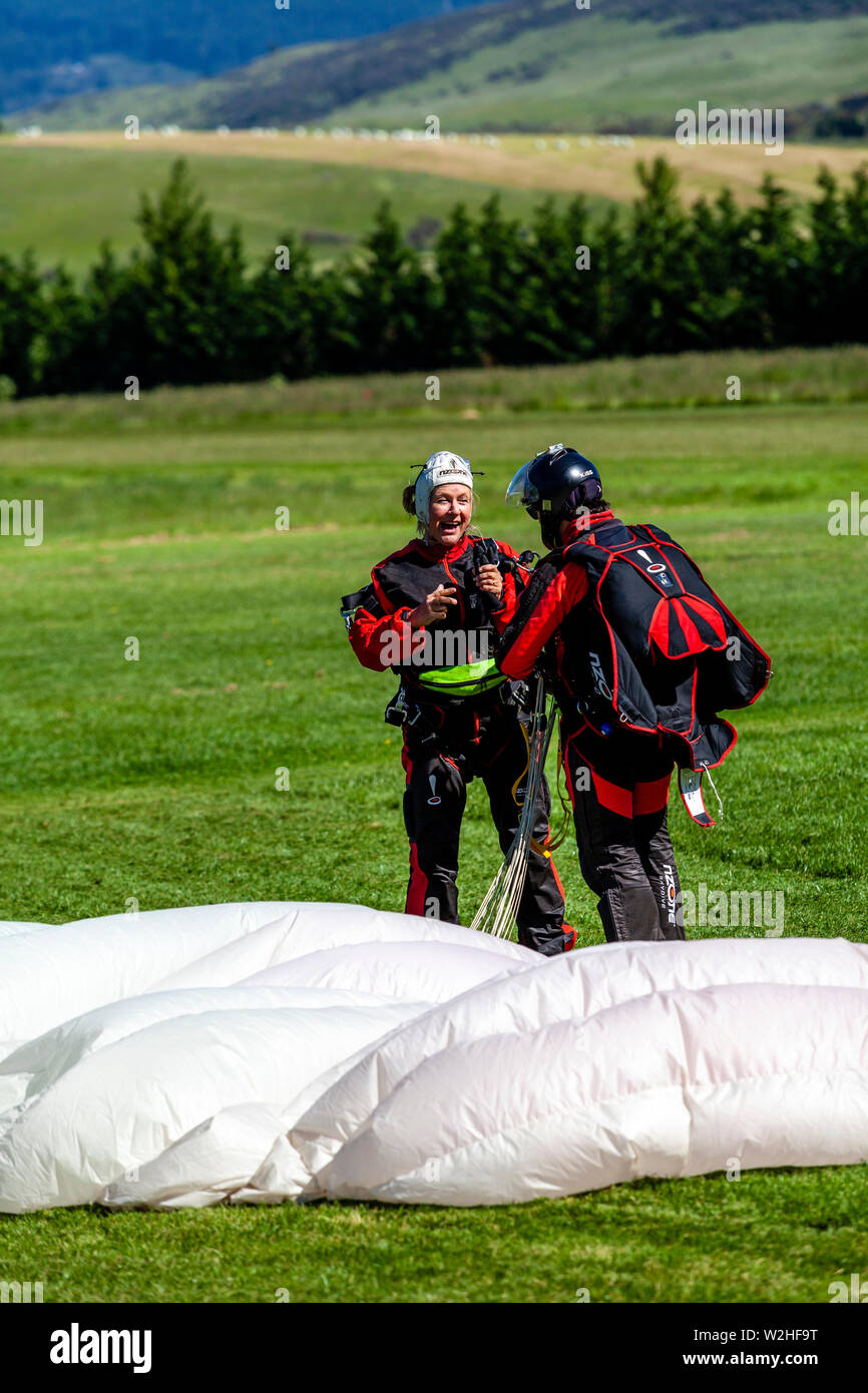 A Skydiving Instructor and Tourist Land In A Field, Queenstown, South Island, New Zealand Stock Photo