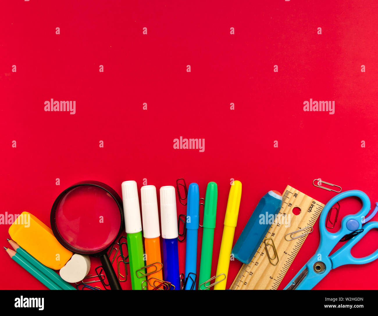 Colorful  school suplies on red  background with copy space. Back to school concept, top view. Stock Photo