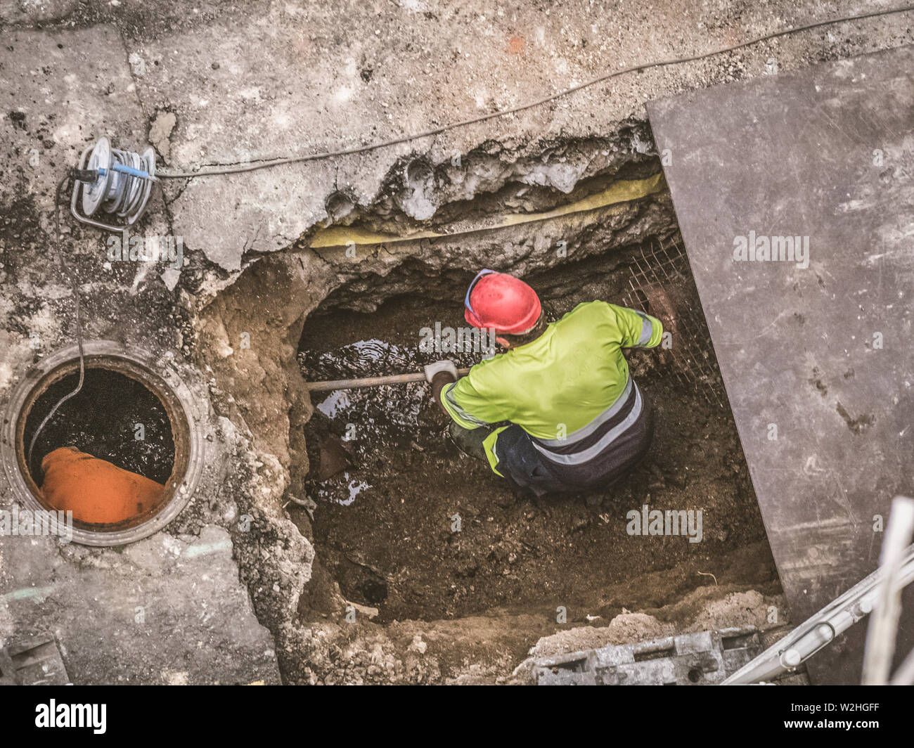 Unrecognizable workers repairing the sewage system in the street Stock Photo