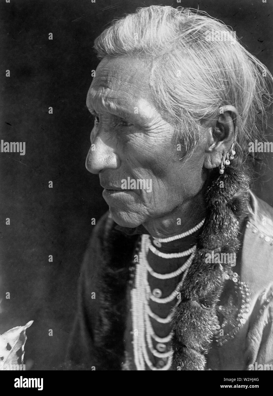 Edward S. Curits Native American Indians - Photograph shows Flathead man, head-and-shoulders portrait, facing left ca. 1910 Stock Photo