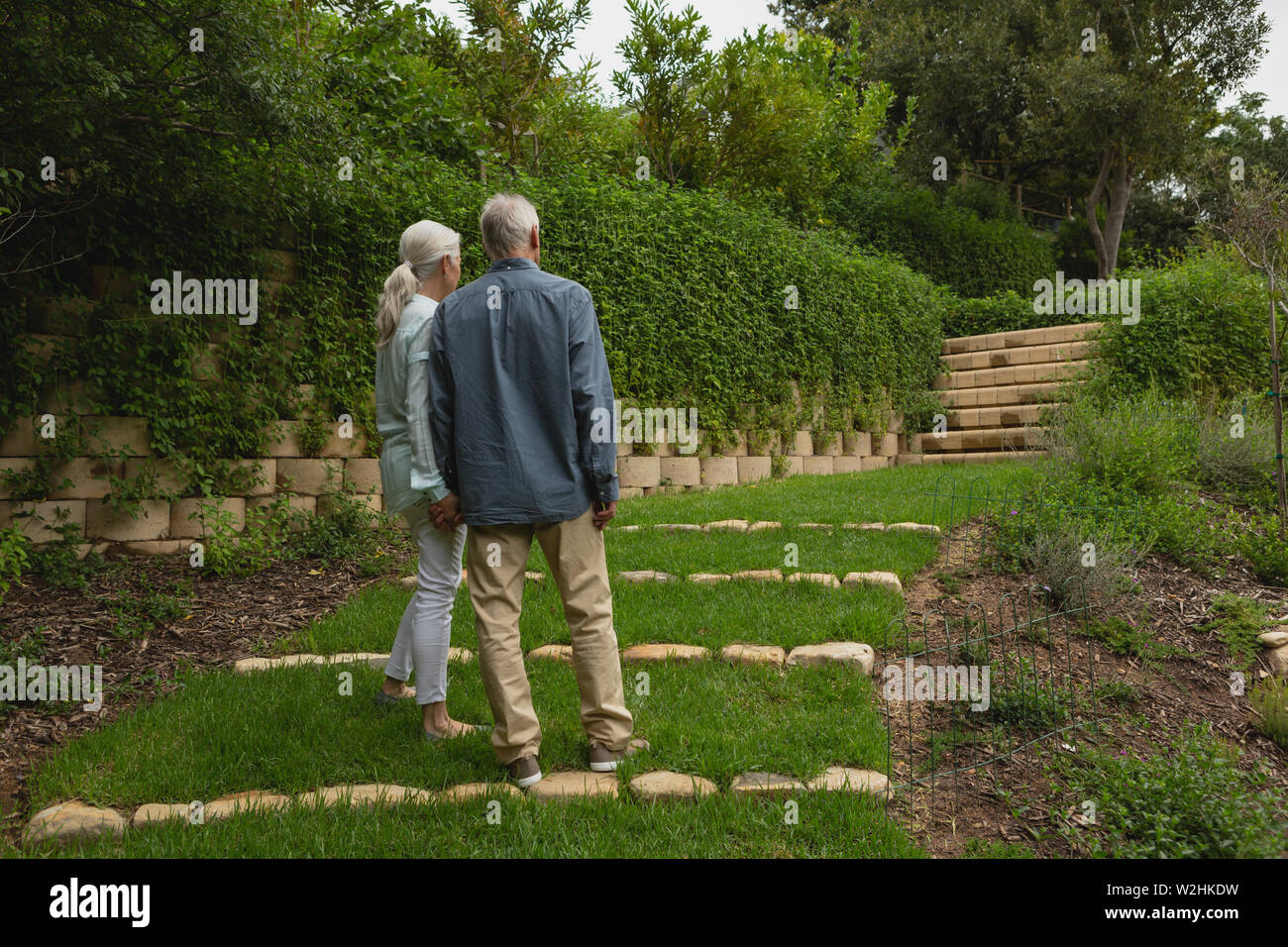 Active senior couple standing together hand in hand at garden Stock Photo