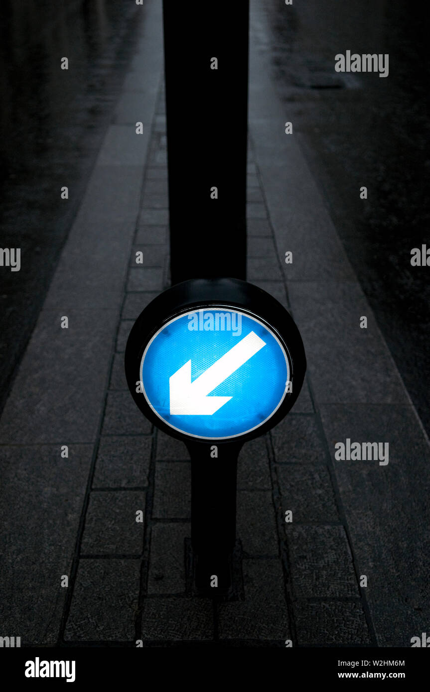 An Illuminated Keep Left Sign On A Central Reservation In A Road Stock Photo