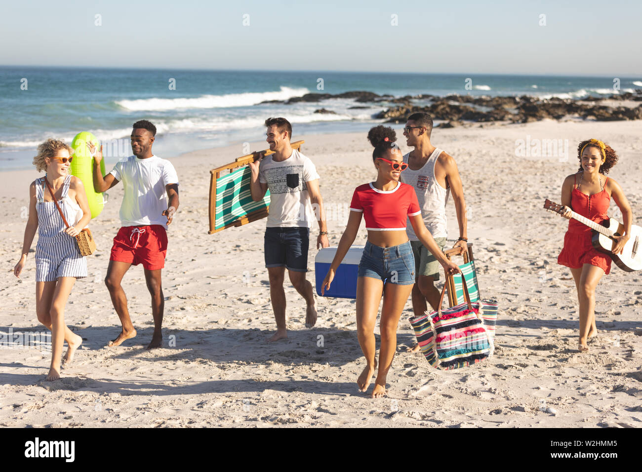 Group of friends walking together on the beach Stock Photo - Alamy