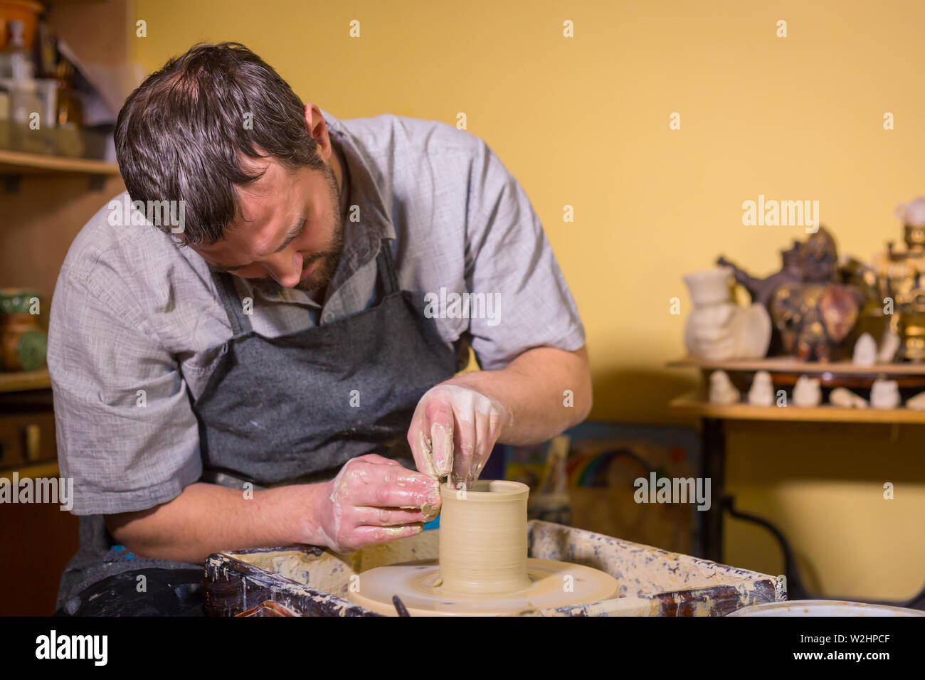 Professional male potter working with clay on potter's wheel Stock