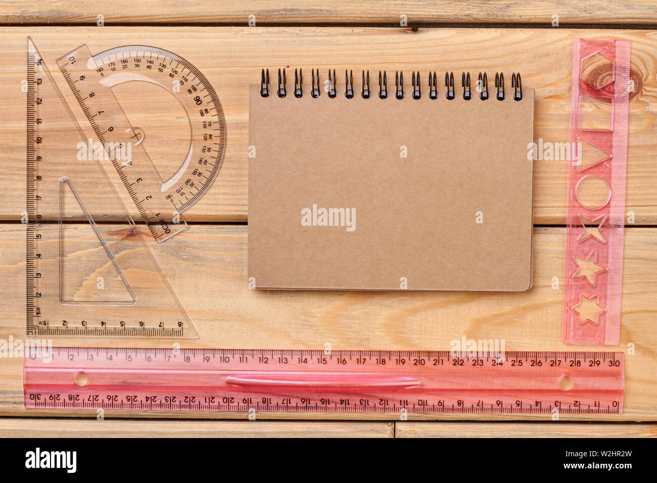 Flat lay of plastic rulers and spiral notebook. Stock Photo